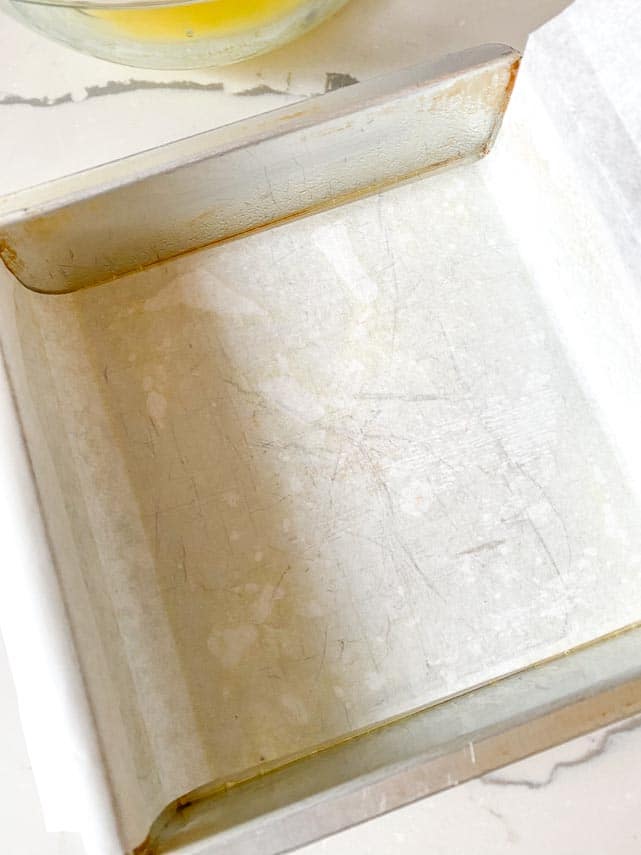 lining an 8-inch square pan with parchment paper