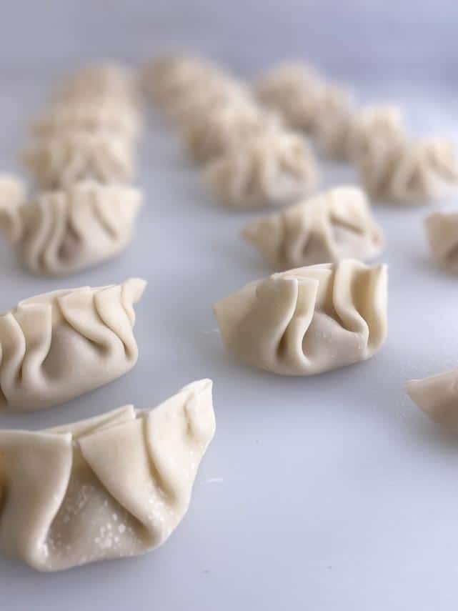 close image of pleated dumplings on white board