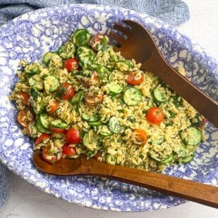 horizontal image of Low FODMAP Orzo Pasta Salad in blue and white oval bowl