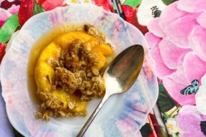 cropped-horizontal-overhead-image-of-Low-FODMAP-peach-crisp-on-white-plate-with-floral-napkins-and-silver-spoons.jpg