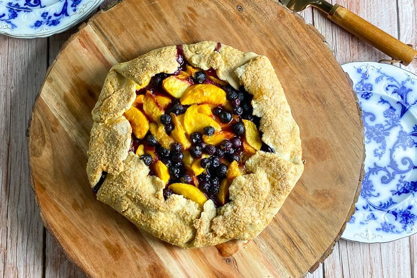 overhead image peach blueberry crostata on wooden board