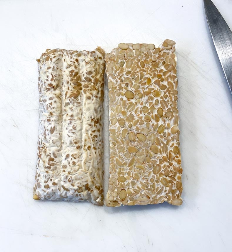 tempeh on white cutting board with knife