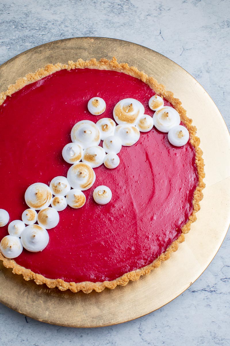 vertical image of low FODMAP Cranberry Curd tart on gold plate