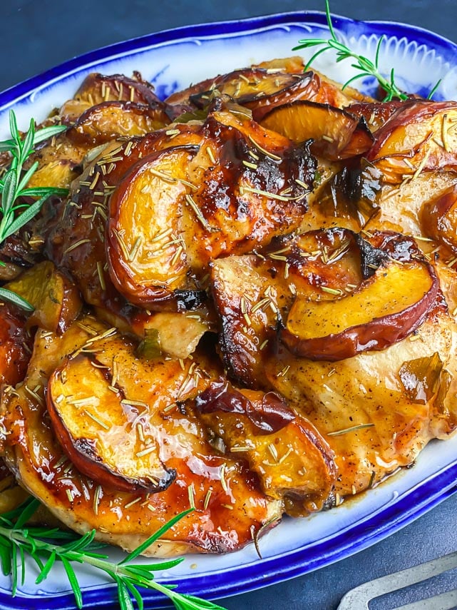 very close image of ow FODMAP Balsamic Chicken with peaches on blue and white platter