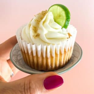 woman's hand holding Low FODMAP Key Lime Cupcake on tiny dish