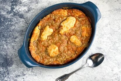 Horizontal baked Low FODMAP Pumpkin Cobbler in blue dish on gray background