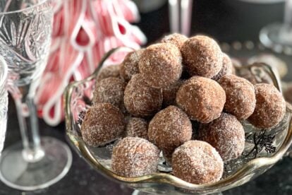 Main close shot of Low FODMAP Chocolate Whiskey Balls in decoratoive glass dishes against Christmas table decor