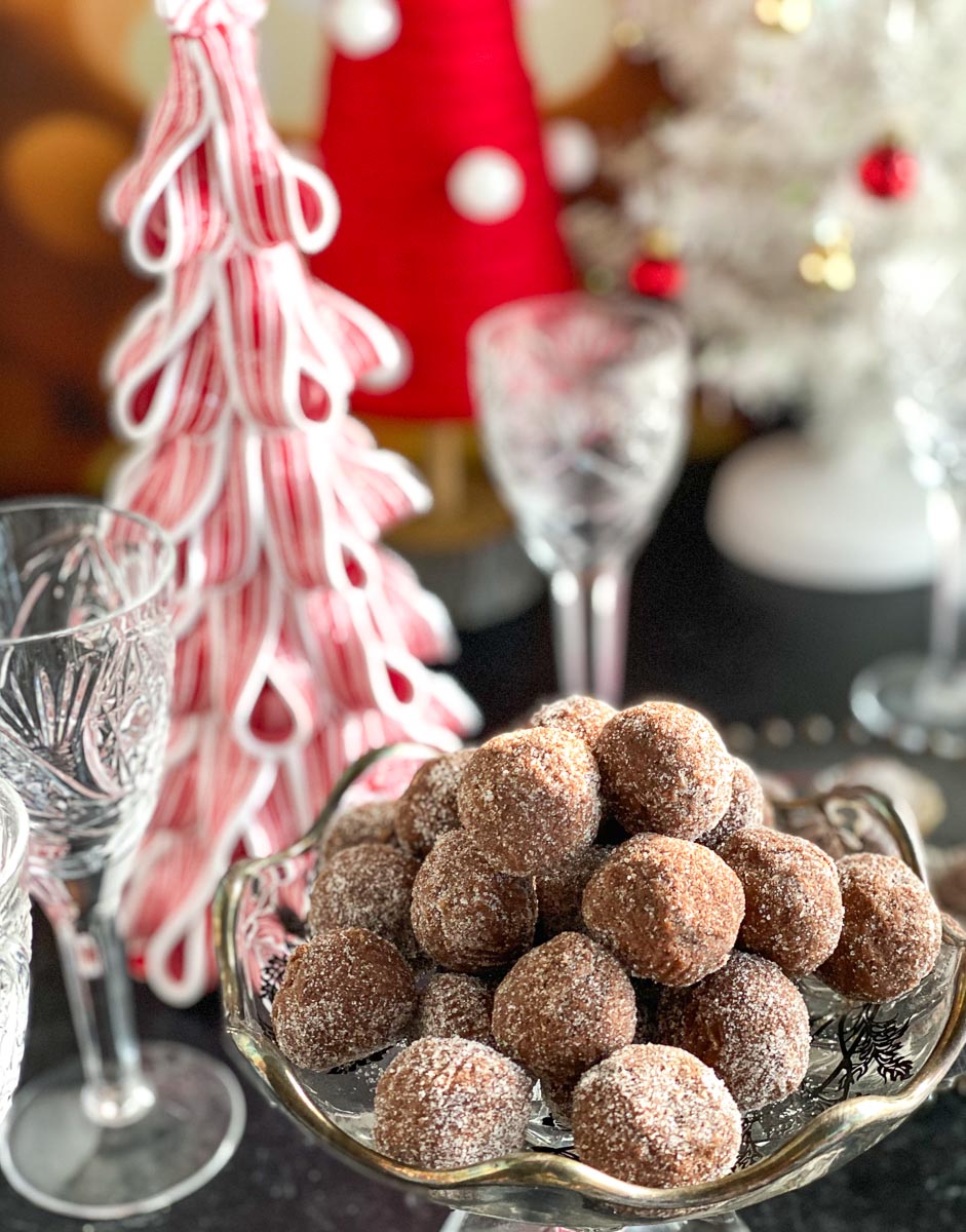 close shot of Low FODMAP Chocolate Whiskey Balls in decoratoive glass dishes against Christmas table decor