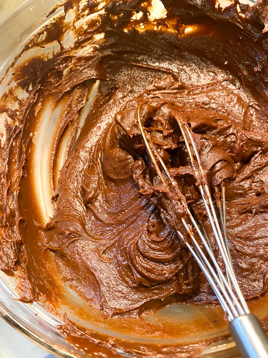 espresso frosting in bowl with whisk