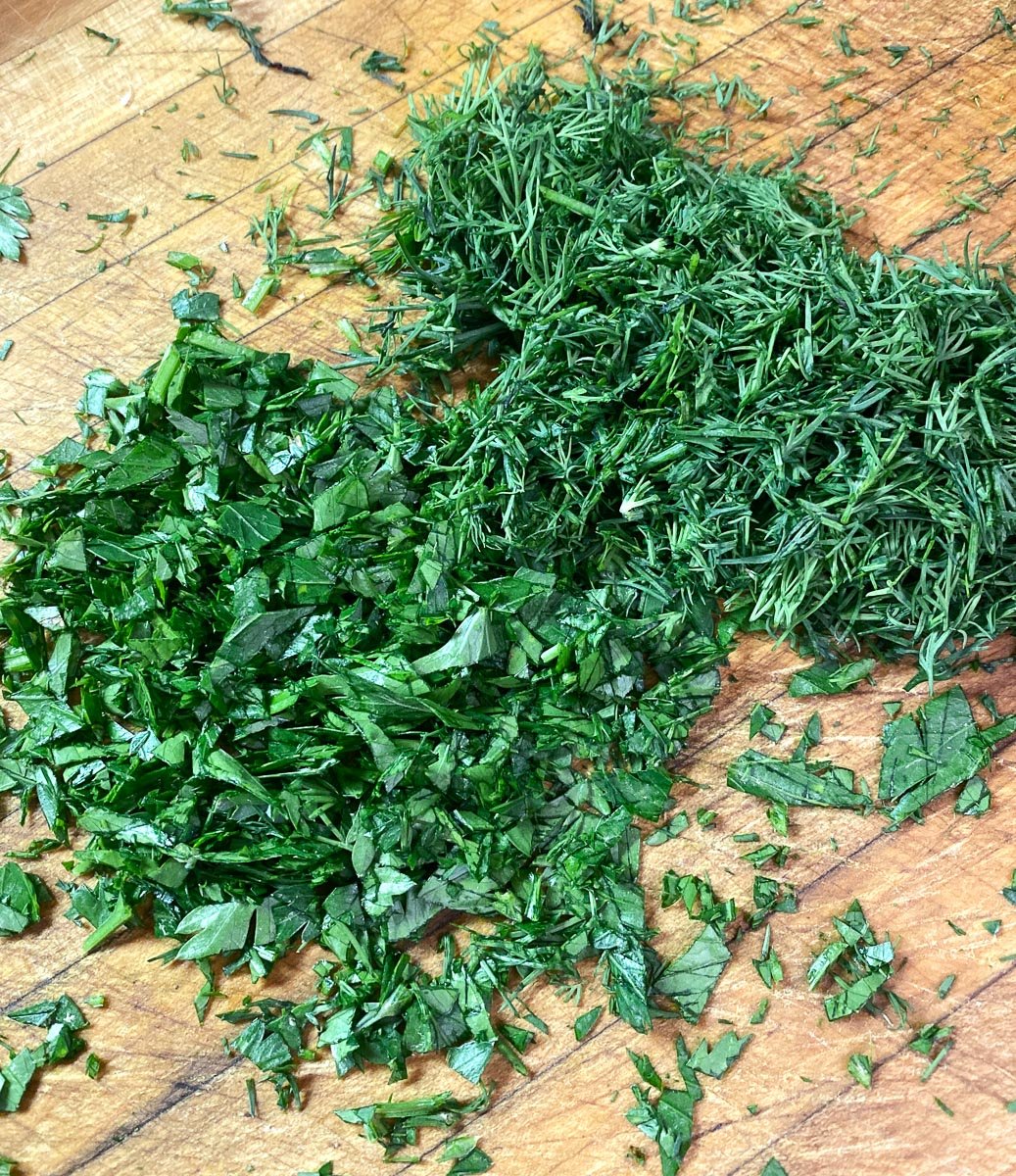 chopped herbs on wooen board