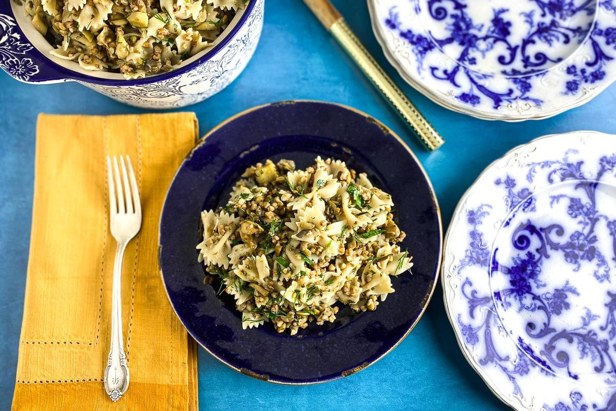 horizontal Low FODMAP Kasha Varnishkes on blue plate; gold napkin