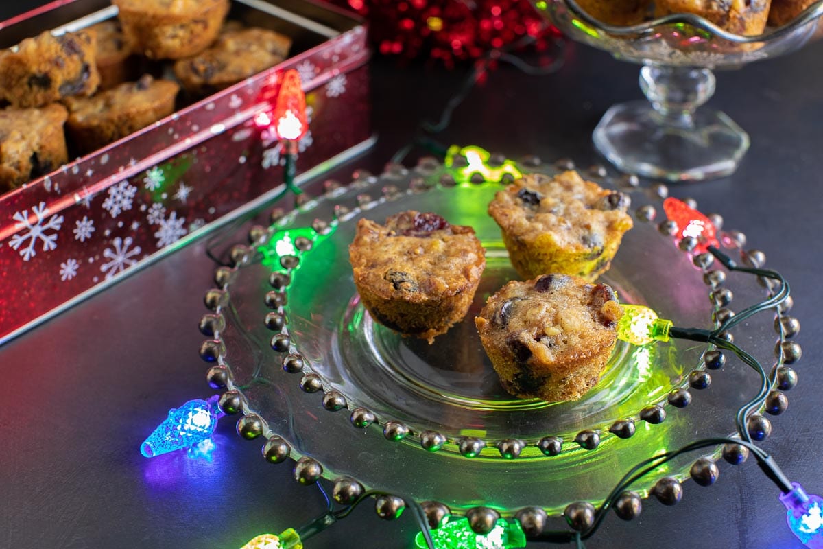 Low FODMAP Fruitcake on decorative glass plate with colored Christmas Lights