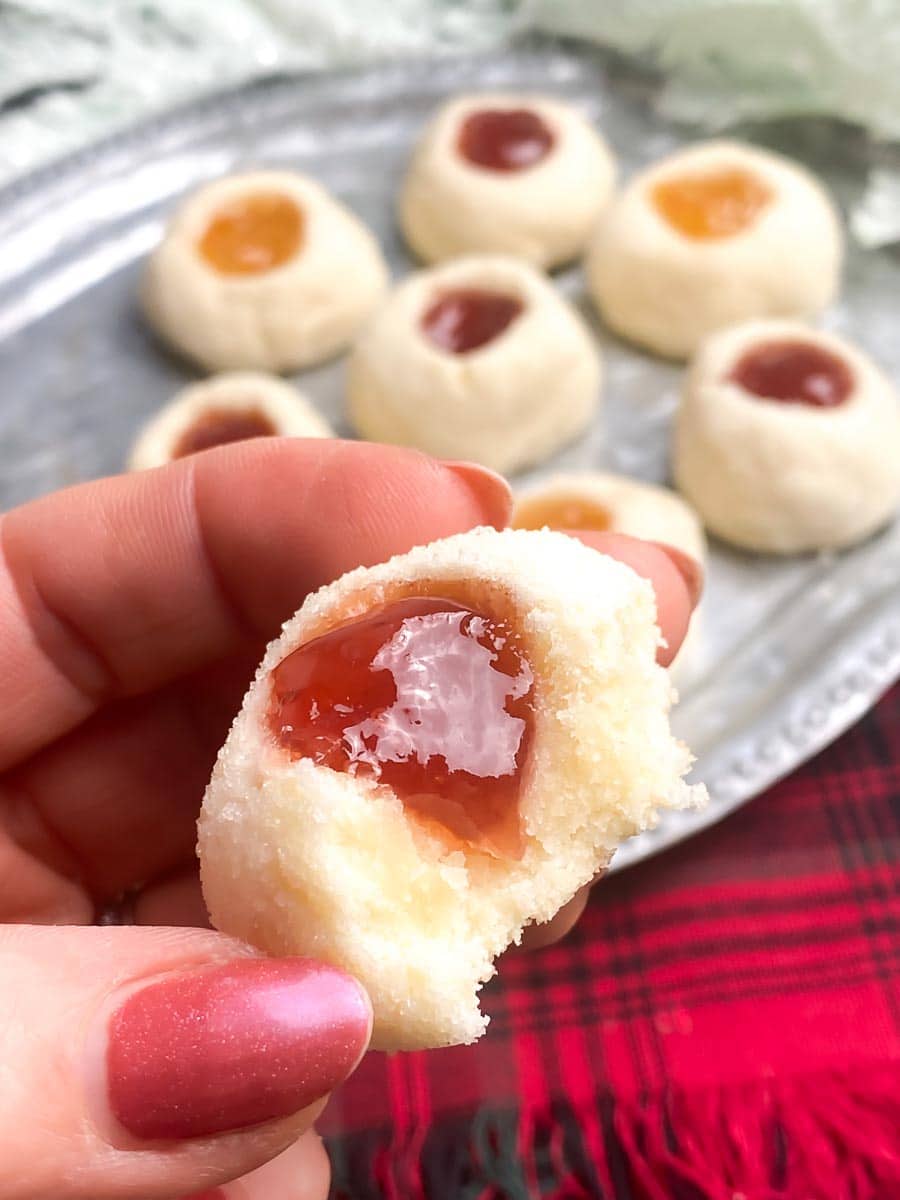 Low FODMAP Thumbprint Cookies on silver platter and held in hand