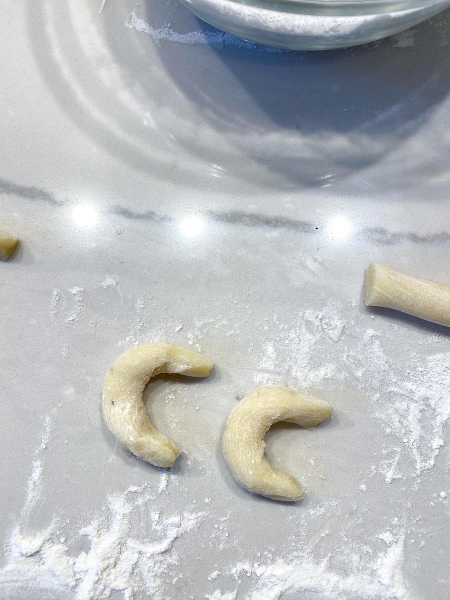 shaping cookie dough into crescents