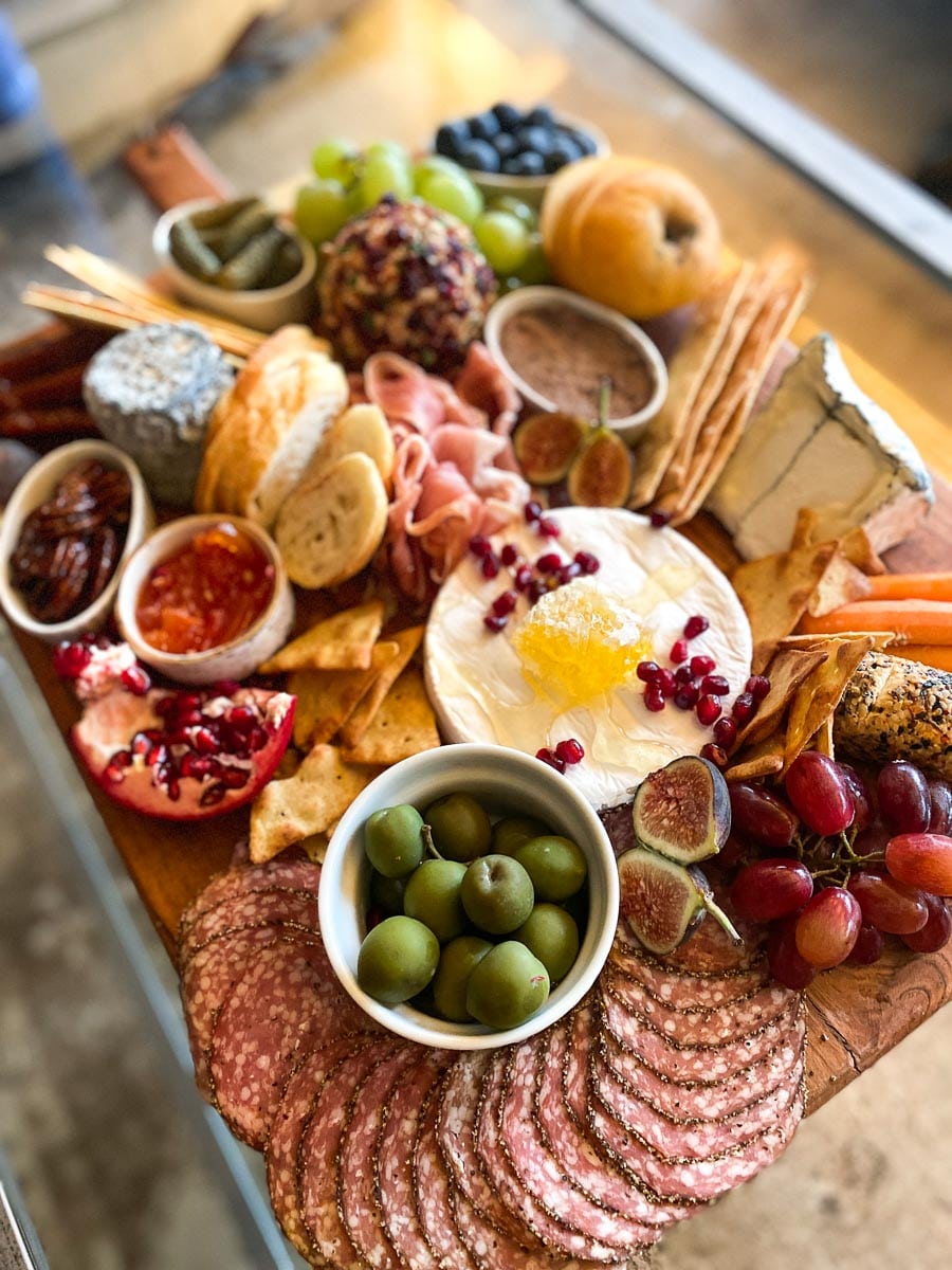 vertical image of Low FODMAP Charcuterie and Cheese board on coffee table