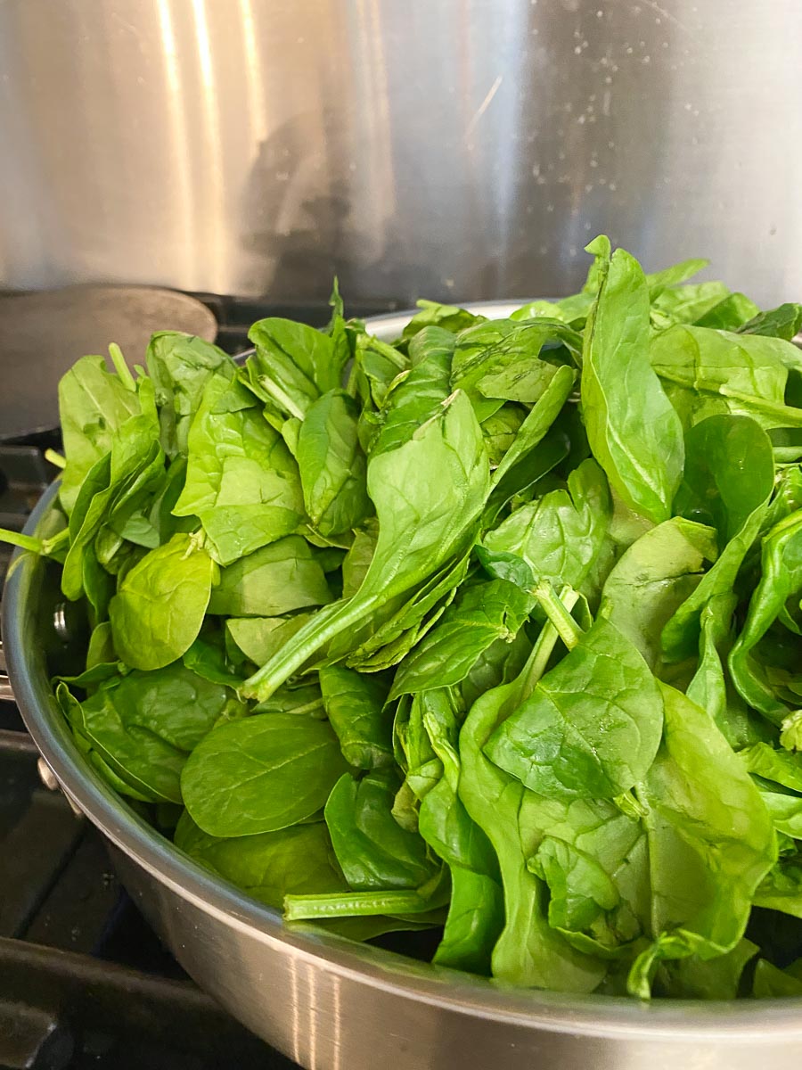 raw spinach in large skillet