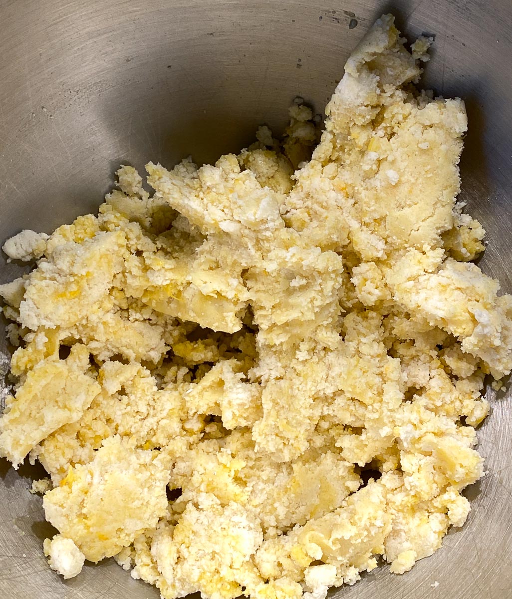 farmer cheese cake crust being made in mixer bowl; egg yolks added