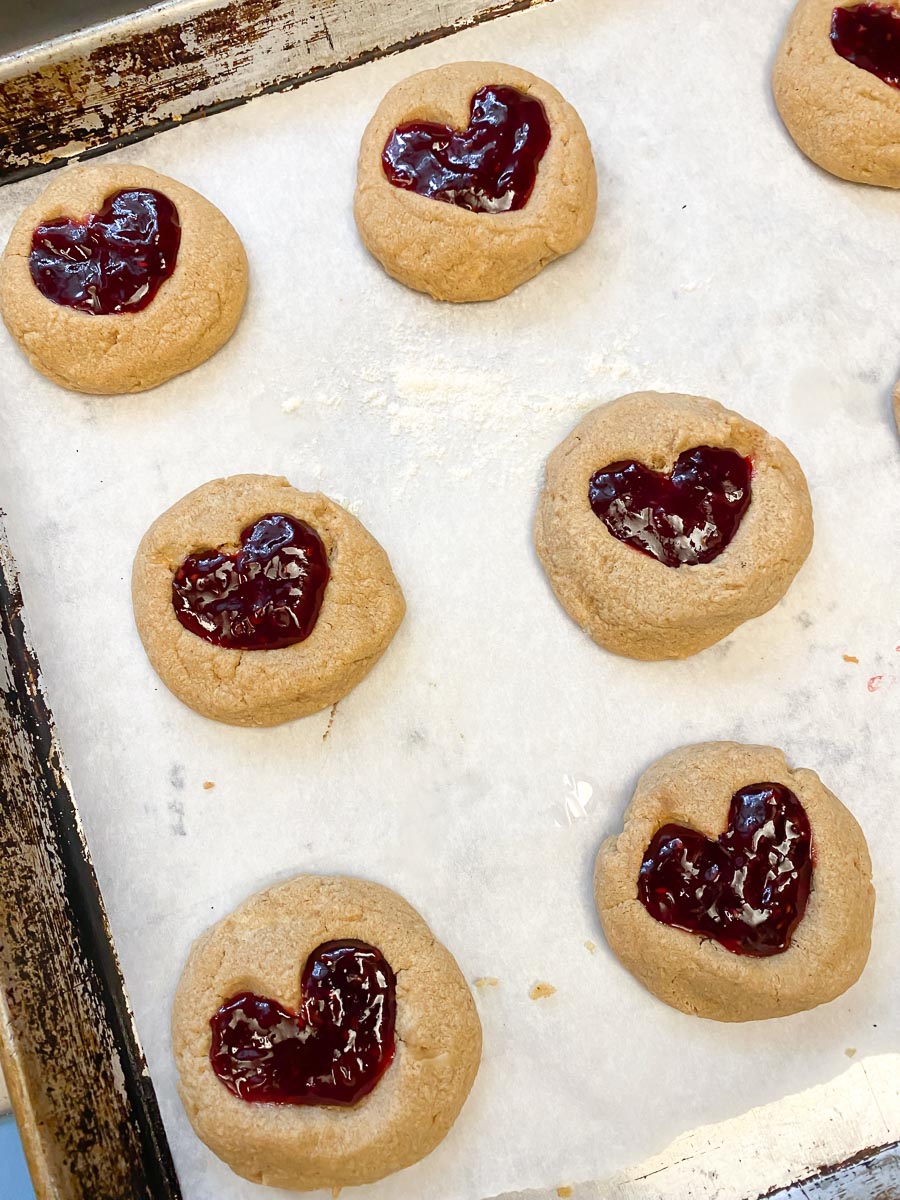 peanut butter cookies with jam heart filling, ready to bake on sheet pan