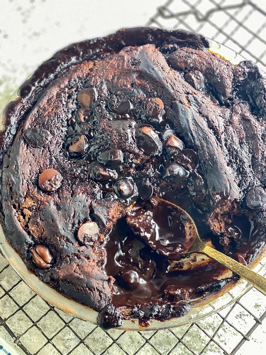 Low FODMAP chocolate Pudding Cake in pie plate on cooling rack showing pudding layer