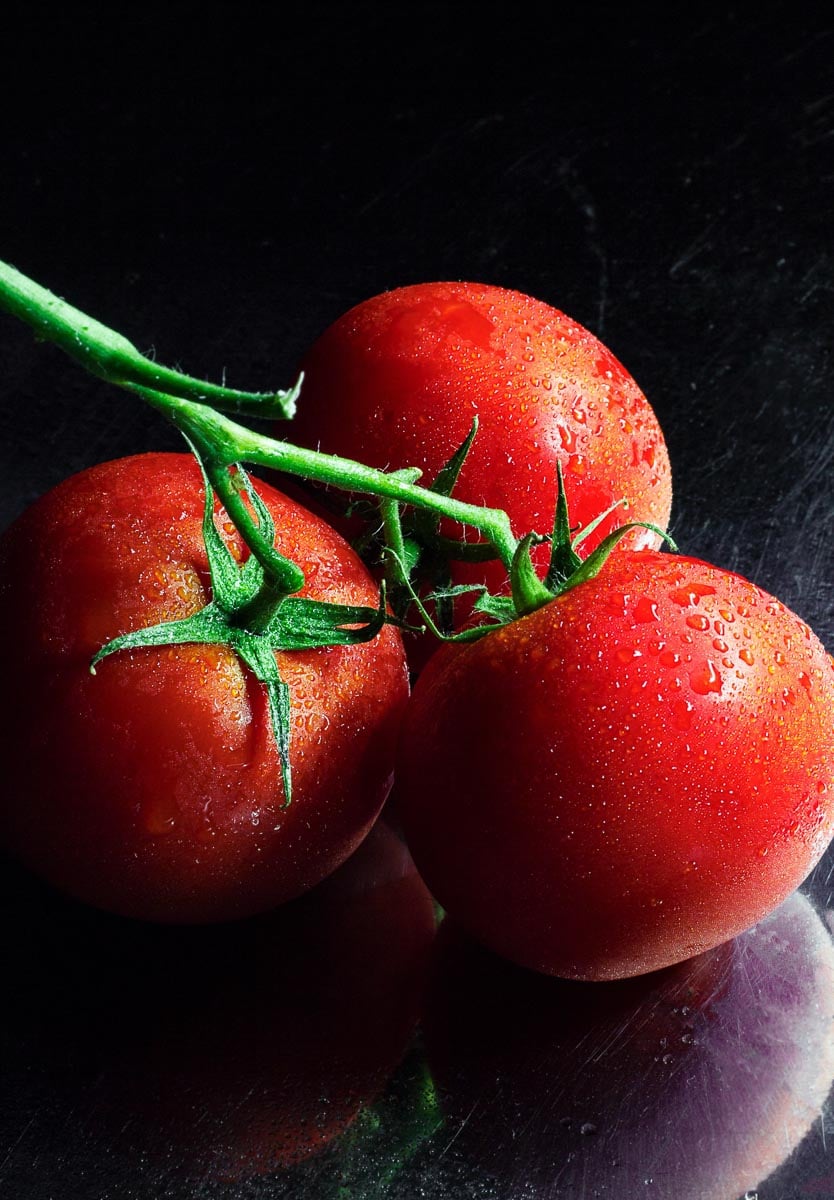 fresh tomatoes against dark background