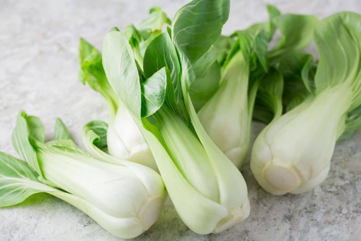 5 baby bok choy on a marble counter