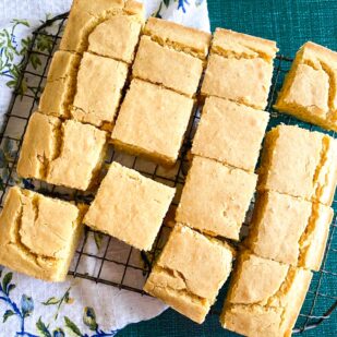 closeup of Low FODMAP cornbread on cooling rack against blue backdrop and flowered cloth