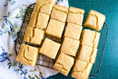 closeup of Low FODMAP cornbread on cooling rack against blue backdrop and flowered cloth