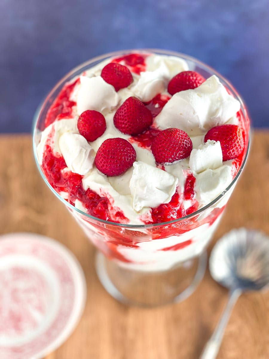 top view of Low FODMAP Eton Mess in glass trifle bowl on wooden table