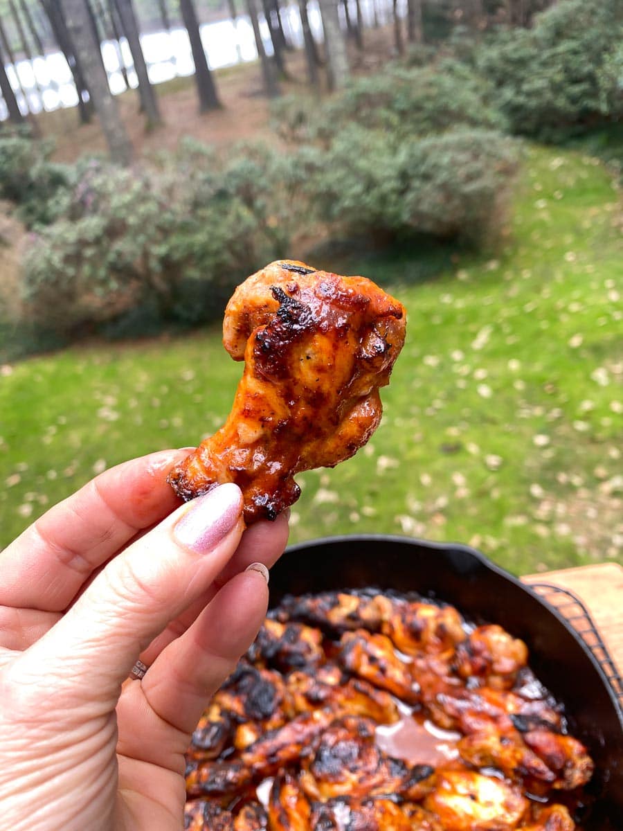 Low FODMAP Hot Honey Chicken Wings in cast iron pan and held in hand