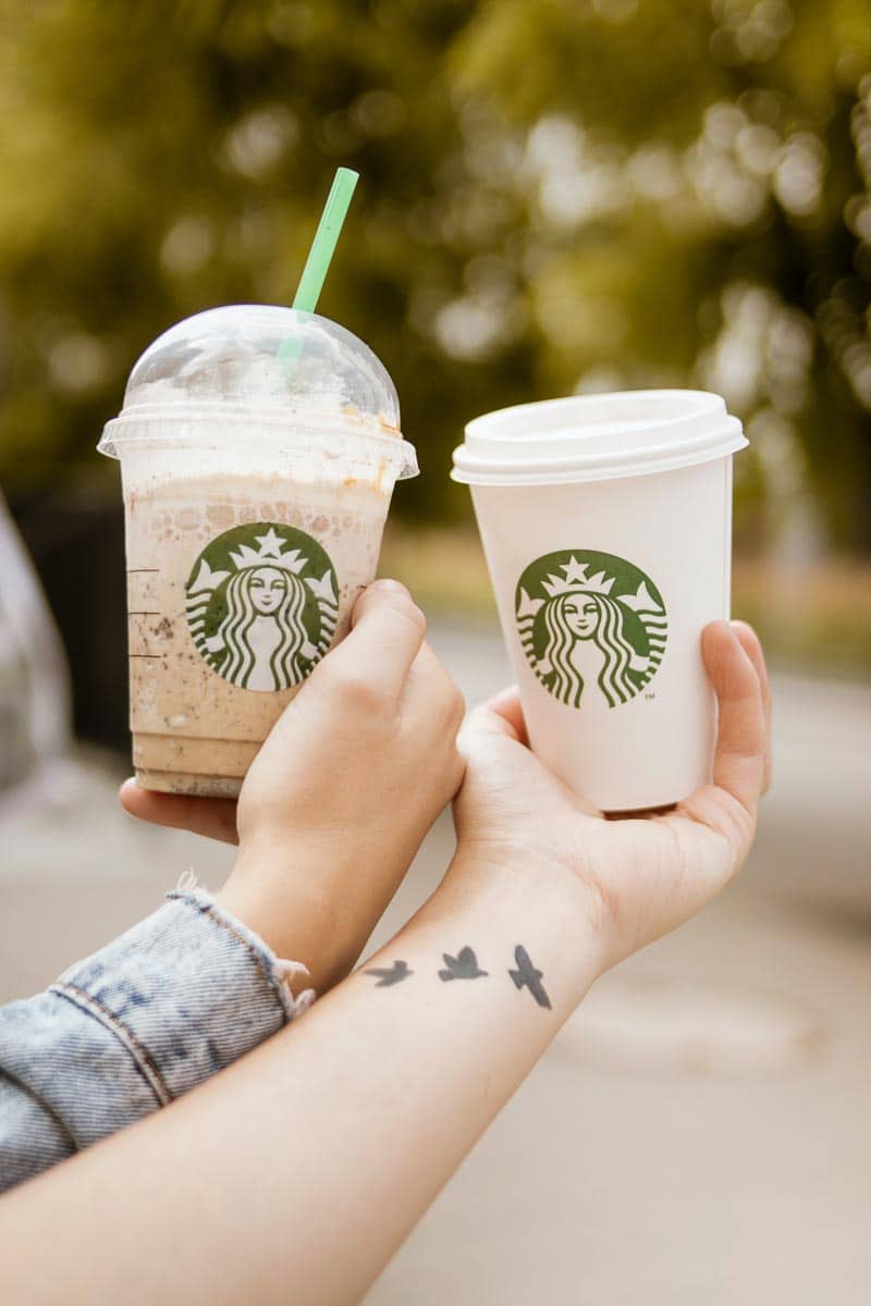 Two Starbucks drinks held in your person's hands, held in the air.
