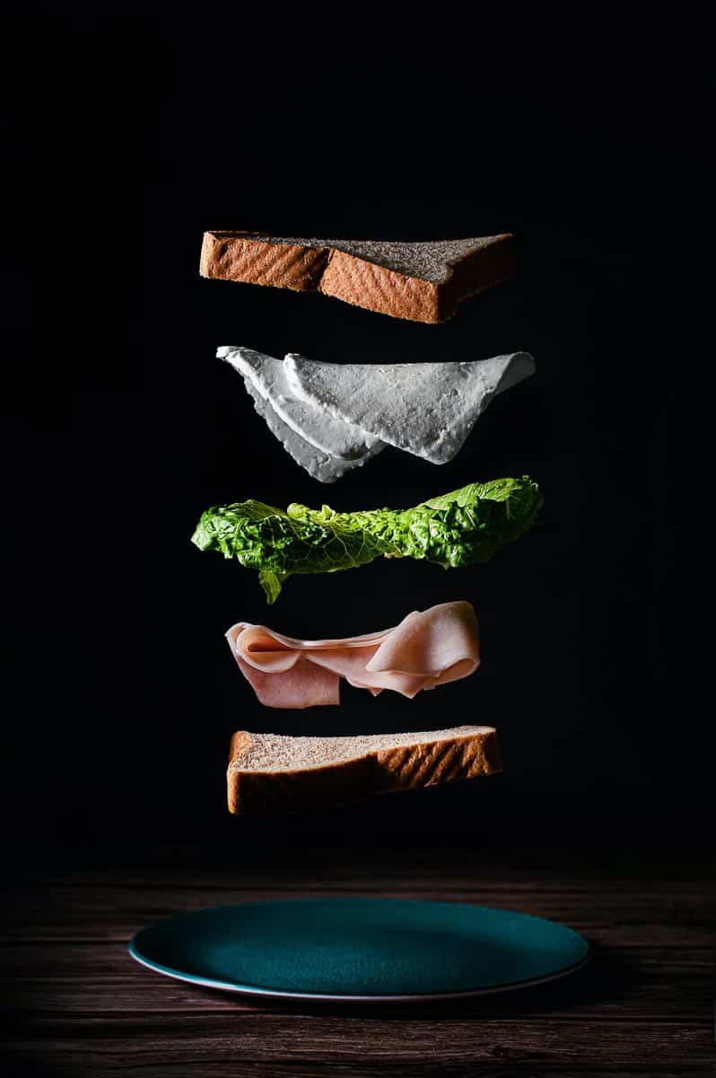 components of sandwich floating in space against black background