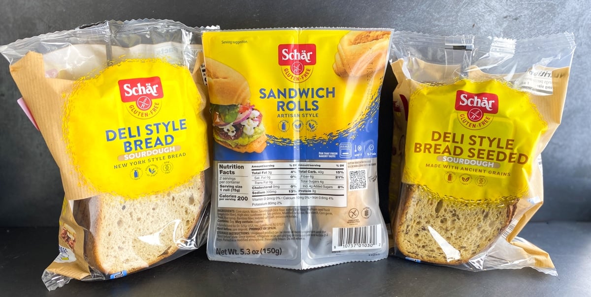 Schar breads in packages against dark background