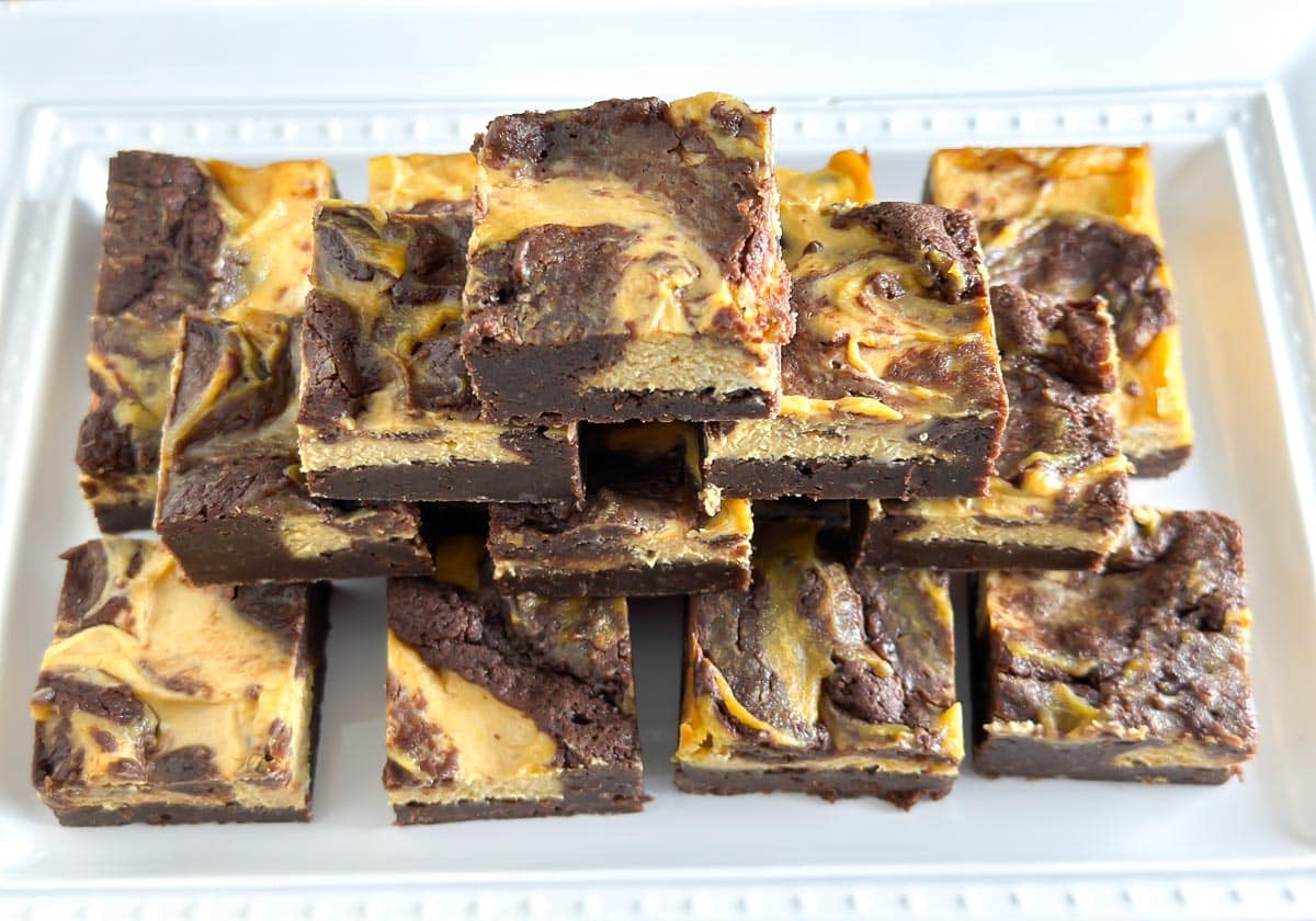 Low FODMAP Pumpkin Cheesecake Brownies stacked on a white plate