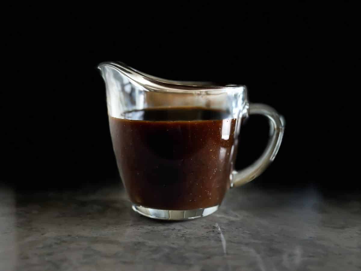 low FODMAP Steak Sauce in glass pitcher against dark background