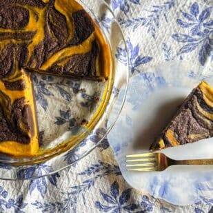 overhead image of Low FODMAP Pumpkin Swirl Brownie Pie on plate with gold fork; whole pie wedge cut out alongside