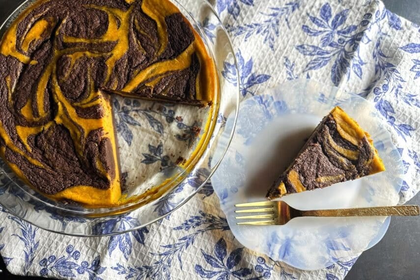 overhead image of Low FODMAP Pumpkin Swirl Brownie Pie on plate with gold fork; whole pie wedge cut out alongside
