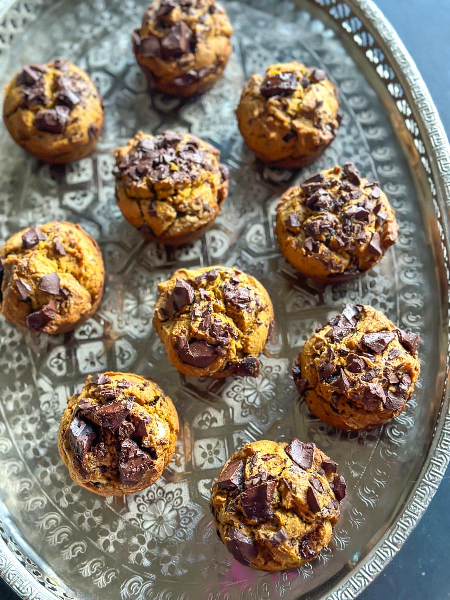 overhead image of low FODMAP Pumpkin Chocolate Chunk Muffins on oval silver tray