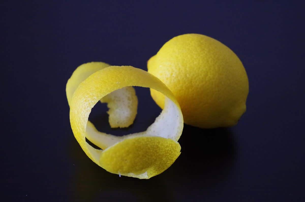 whole lemon and peel against dark background