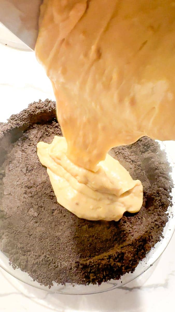Pouring peanut butter pudding into crust