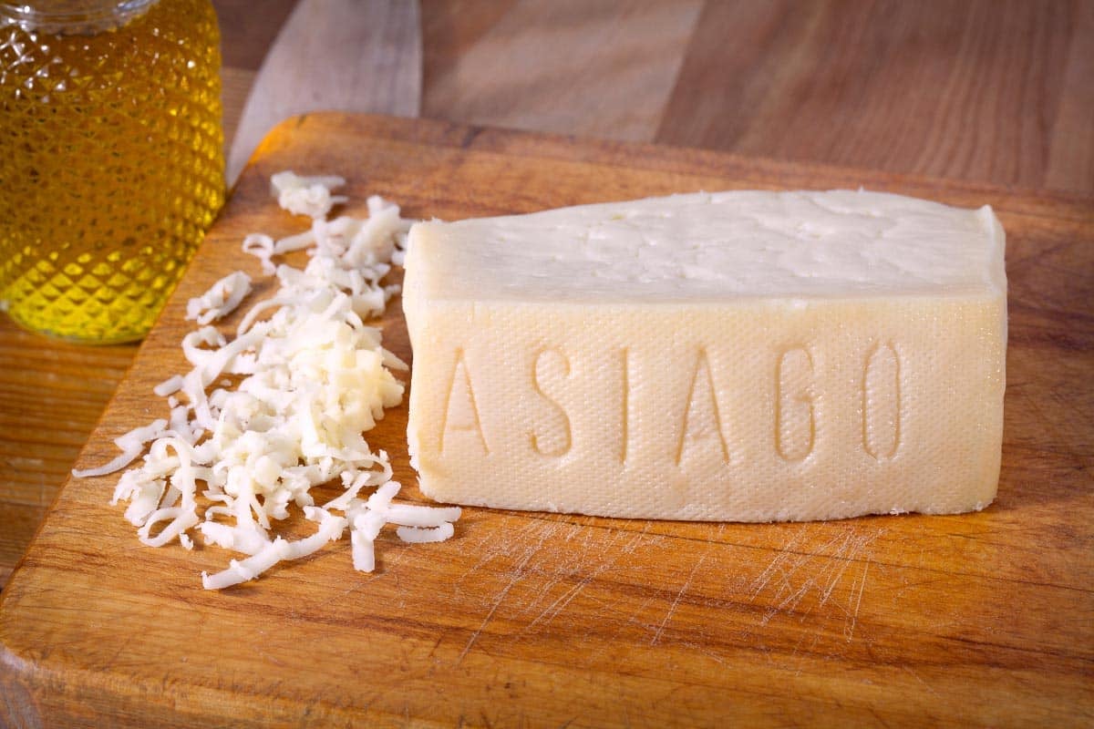 Asiago cheese wedge and shreds on board