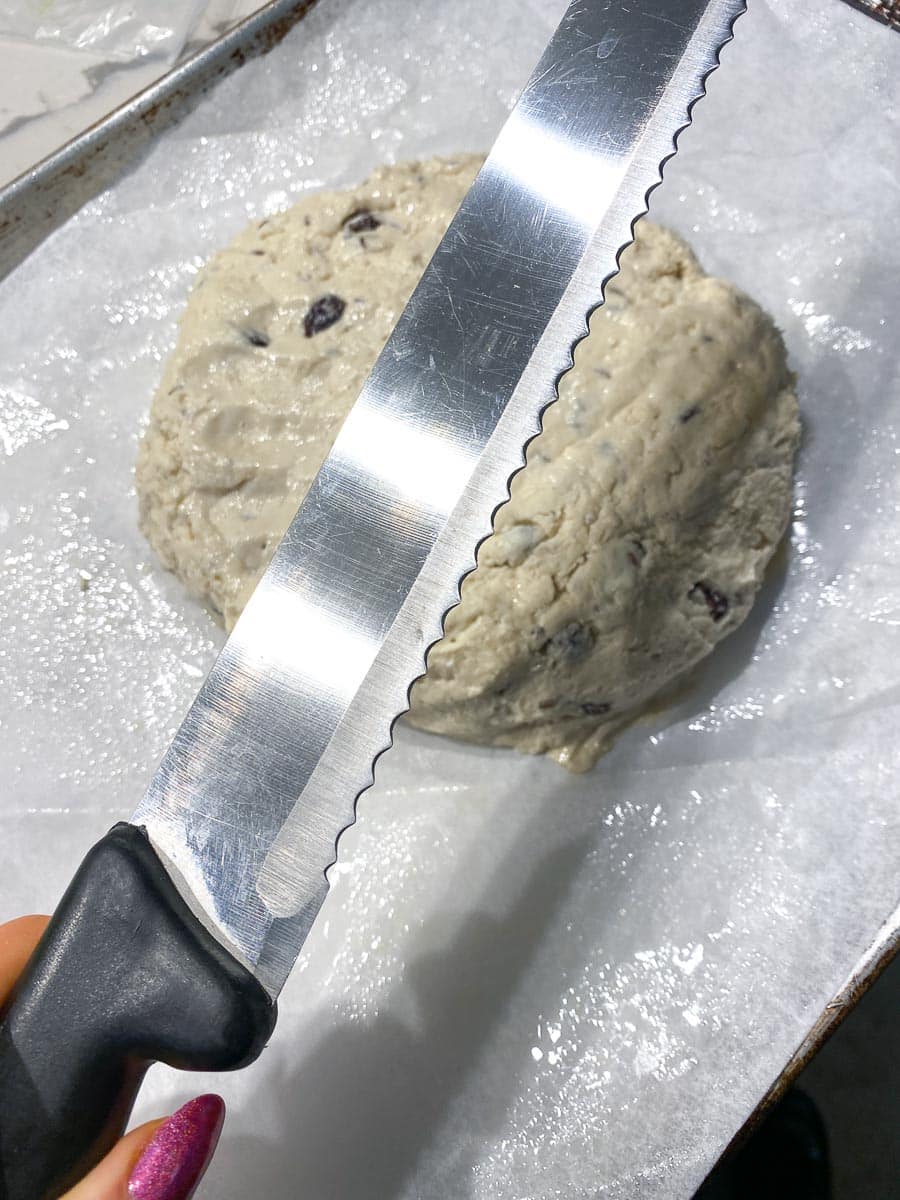 blade of serrated bread knife held over Irish Soda bread unbaked