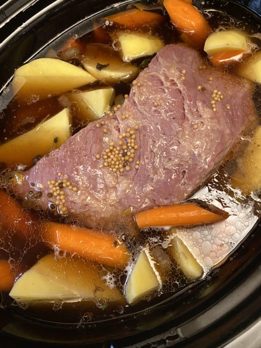 carrots and potatoes added to corned beef in slow cooker