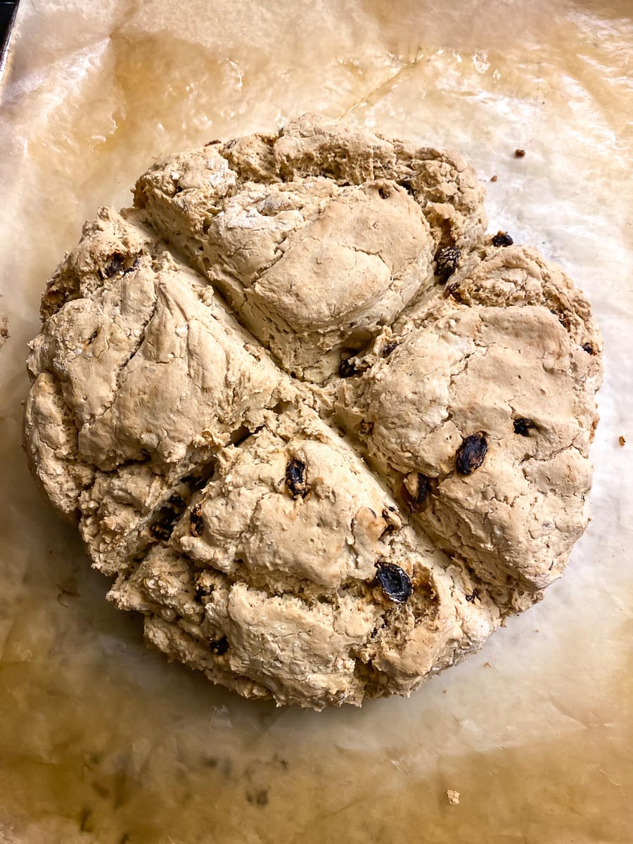 overhead image of loaf of vegan low FODMAP Irish Soda bread on parchment paper