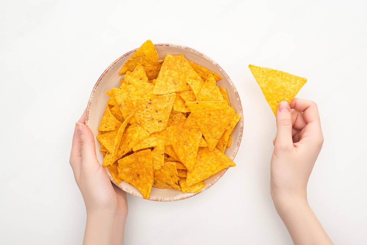 tortilla chips in bowl, white background