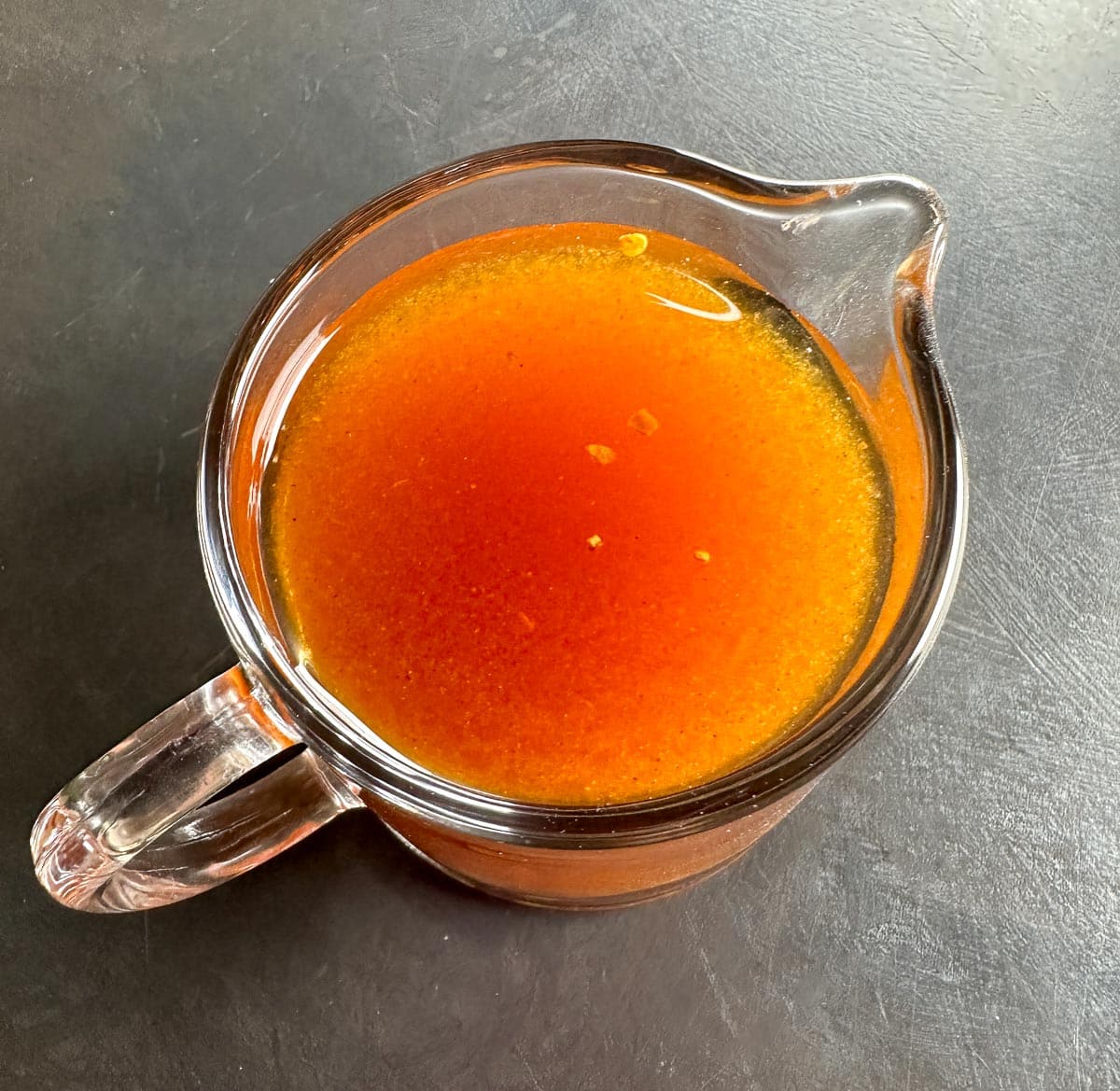 Low FODMAP Vinegar BBQ Sauce in a glass pitcher; top view.