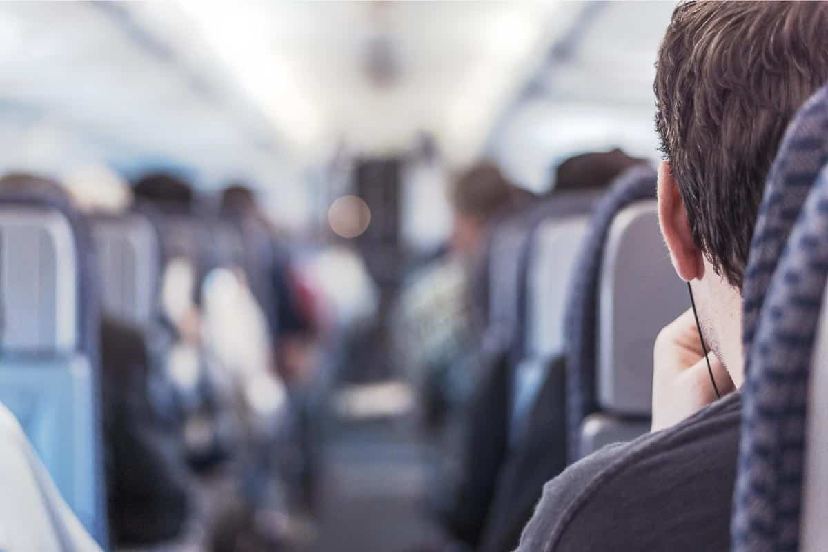 back of man's head in seat on plane.
