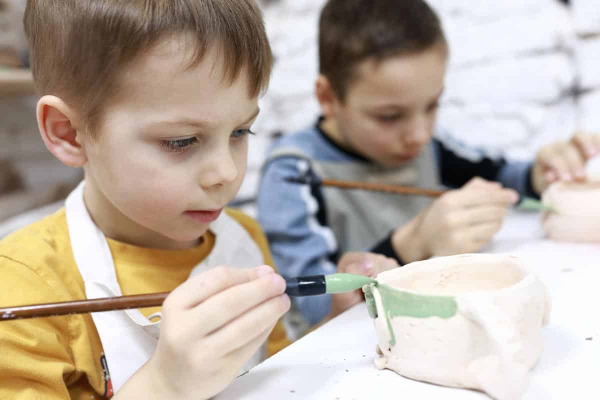 boy painting ceramics.
