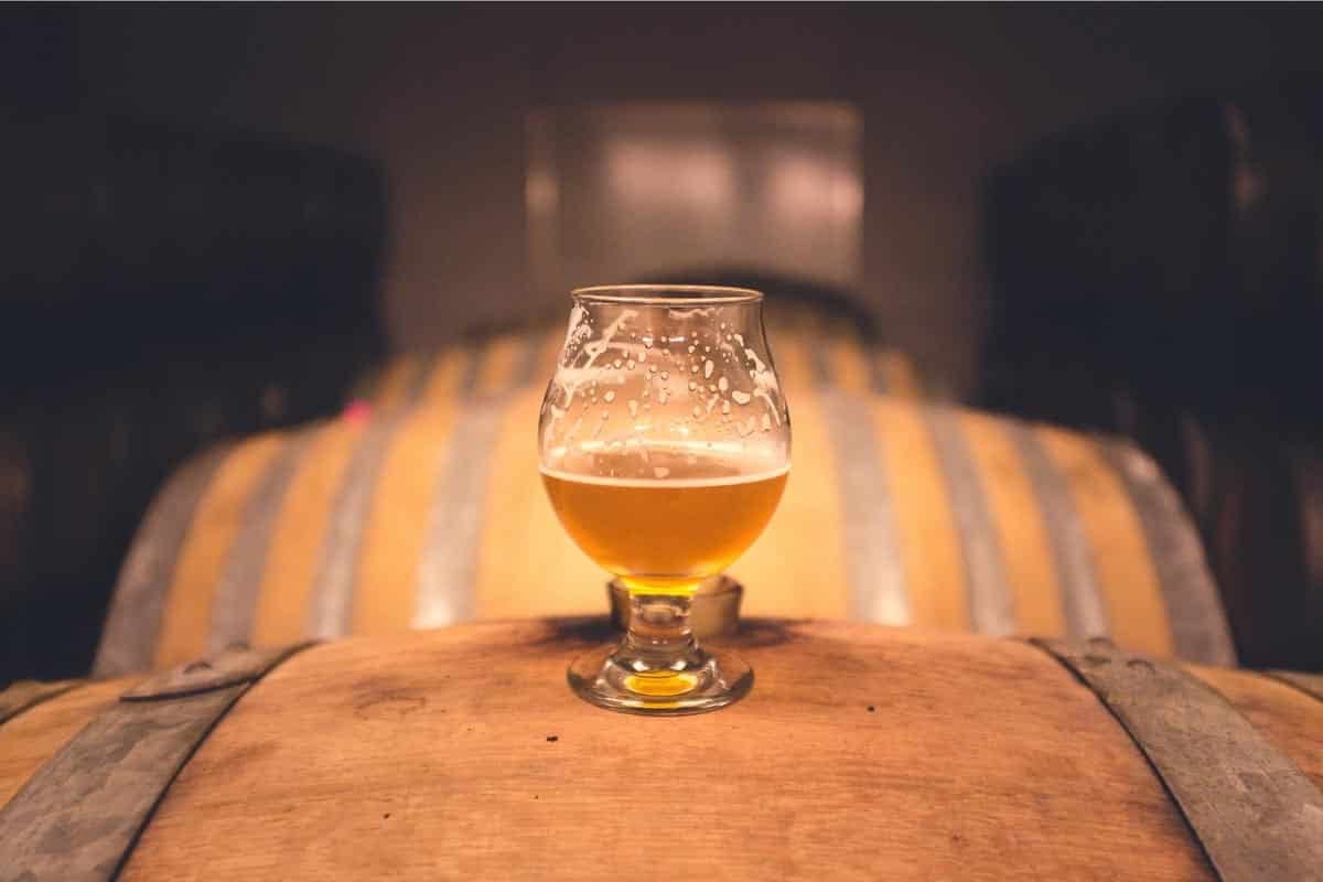 hard cider in glass on barrel.
