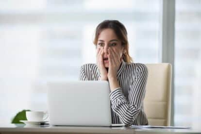 shocked woman looking at laptop.