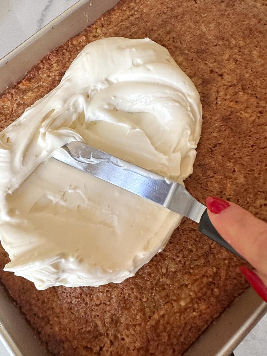 spreading frosting on cake with small offset spatula.
